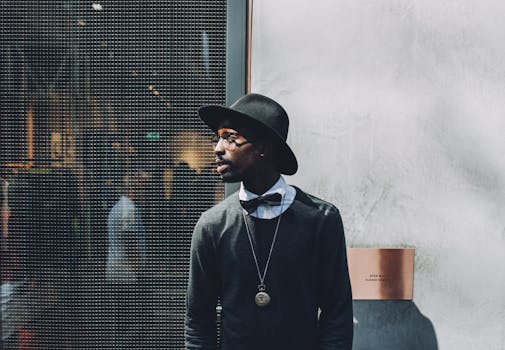 pexels-photo-175696-175696 Chic portrait of a fashionable man wearing a hat and bow tie against a textured wall.